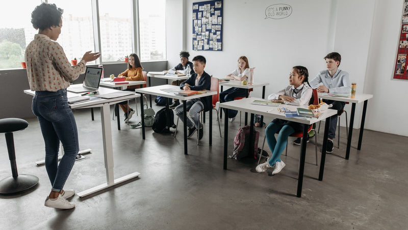 Teacher working with students in a classroom, representing a volunteer English teaching placement