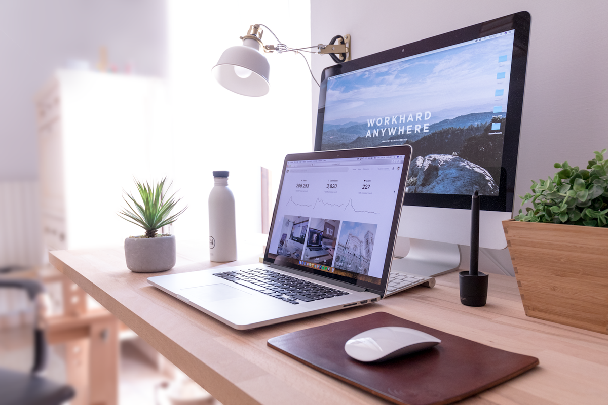 Laptop and notebook set up for an online English teaching video call at a home desk