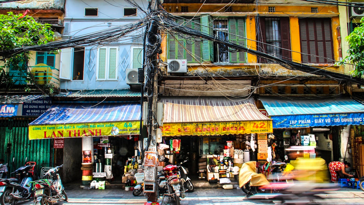 Motorbike passing a shopfront in the Hanoi Old Quarter, Vietnam, where TEFL certified English teachers find language center work