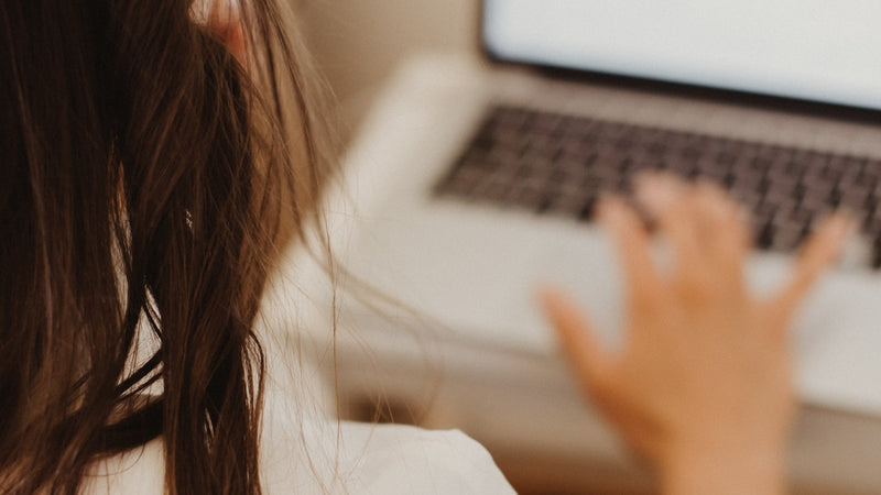 South African woman teaching English online from a home desk on a laptop