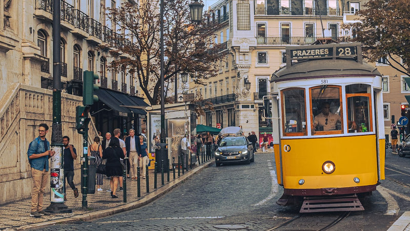 Yellow tram climbing a Lisbon street, an everyday sight for Americans living in Portugal