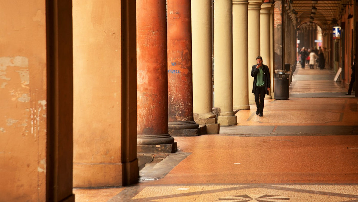Person walking under the arcades of an Italian city street, where many English language schools are based