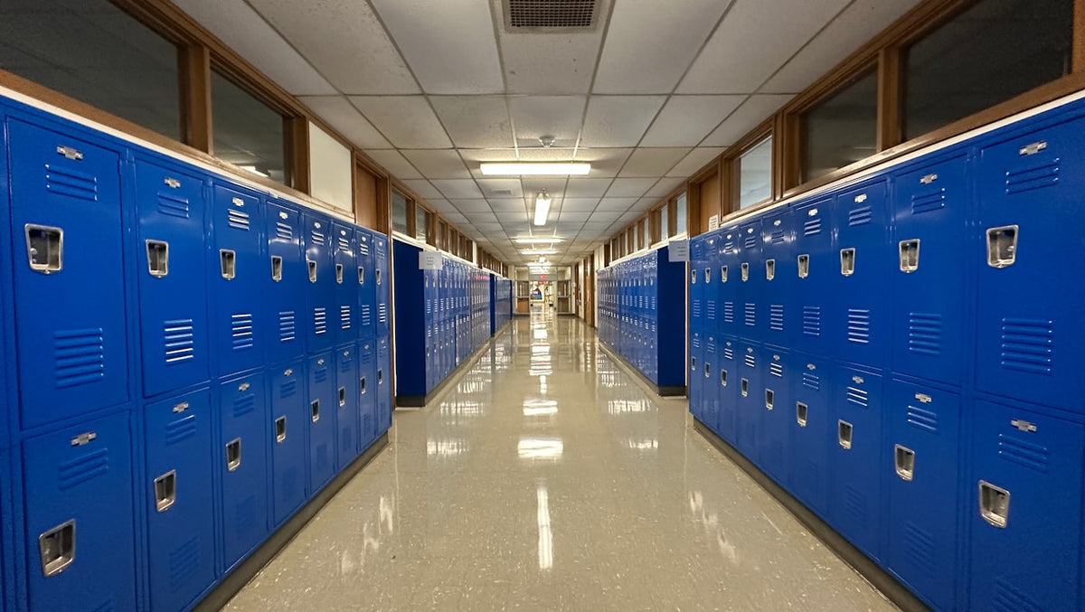 A school hallway lined with blue lockers, where ESL certified teachers work in US public schools