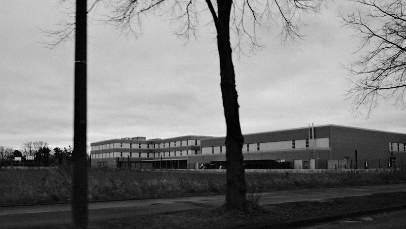 A German school building seen from the street behind trees