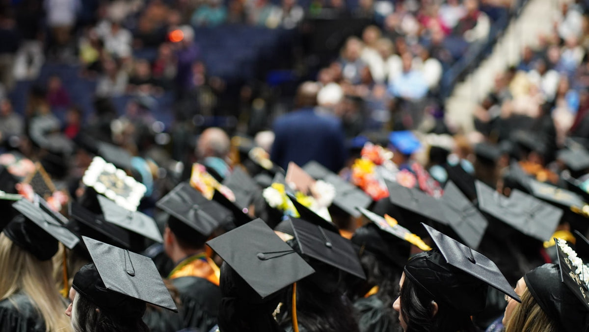 Graduates in caps and gowns at a university ceremony, the postgraduate route for TESOL masters students