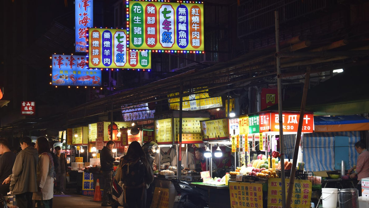 Night market stalls with glowing signs in Taipei, where English teachers in Taiwan eat cheaply