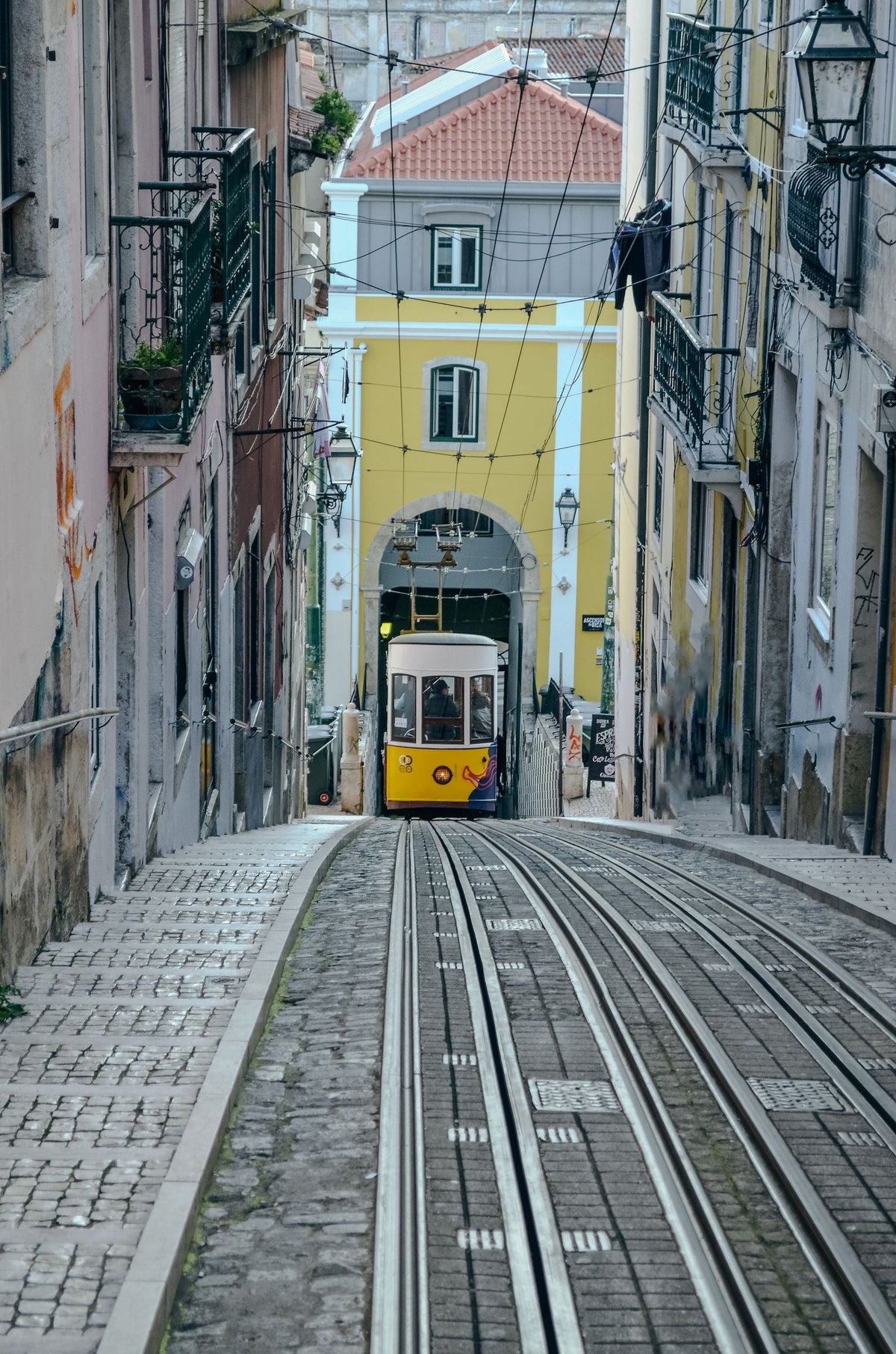 Colorful tram on a cobbled Lisbon street, a city where a Portugal English teacher salary must stretch furthest