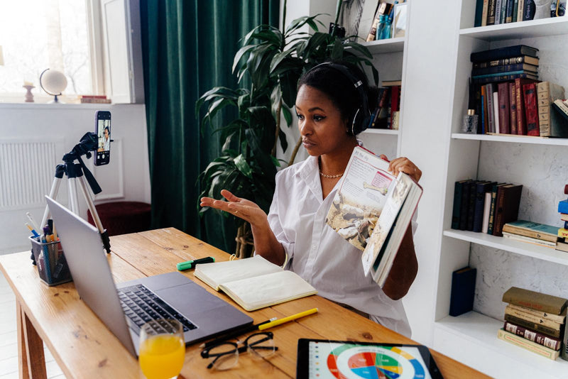 Woman teaching on Cambly through a video call on her laptop at home