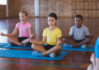 Children practising yoga and mindfulness activities as part of an English language learning lesson.
