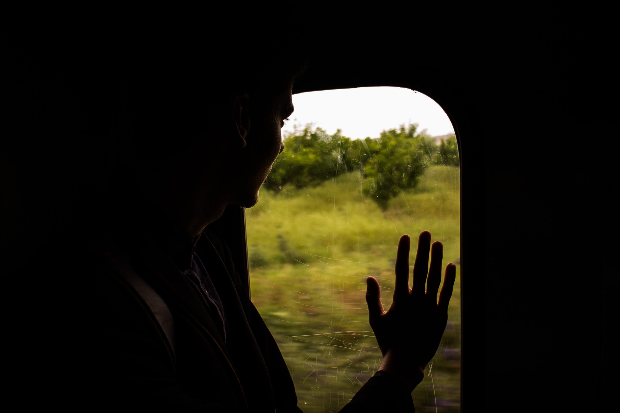 Person looking out of the window of a train.