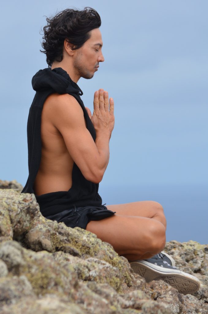 A man meditating on a hill 
