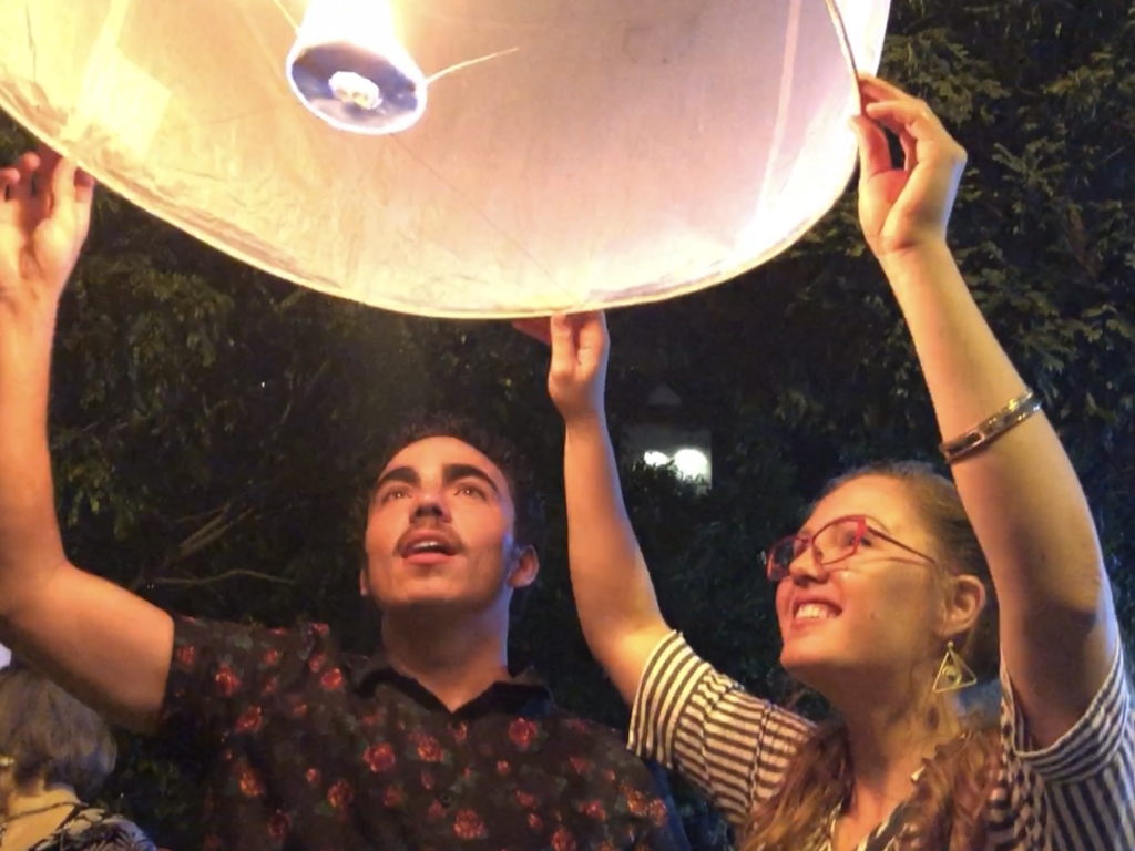 People leaving a lantern into the sky to make a wish.