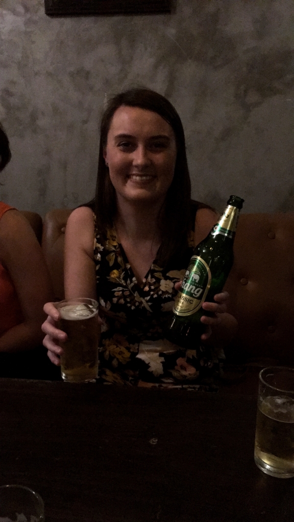 Sarah enjoying a bottle of Chang with the new interns.