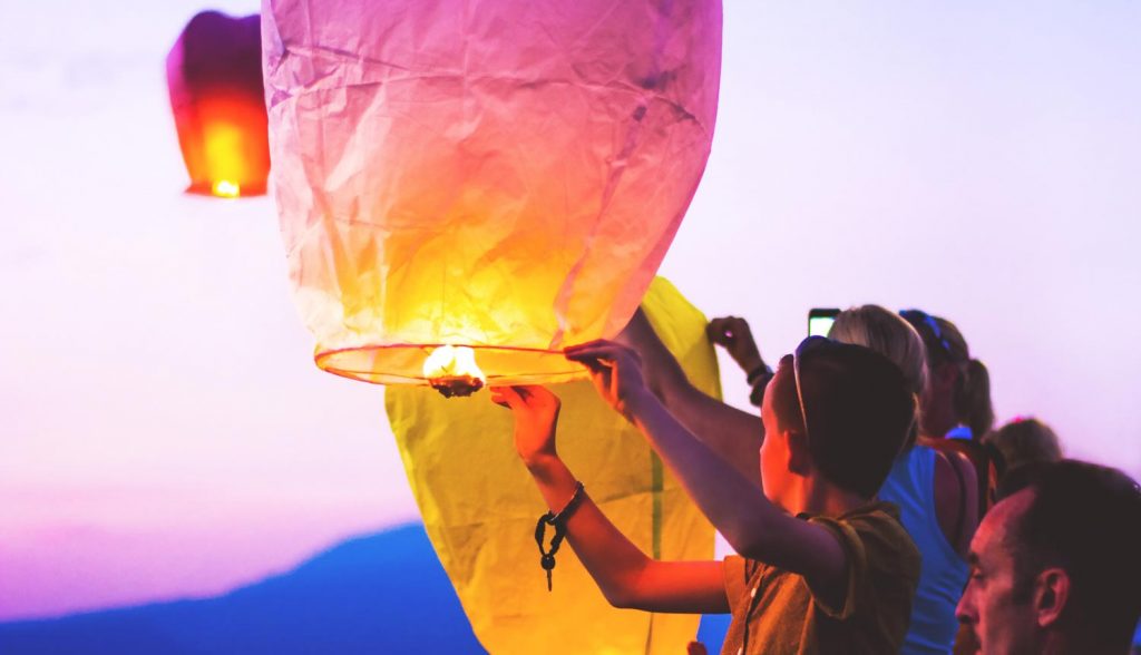 A group lighting a lantern, floating lanterns Myanmar